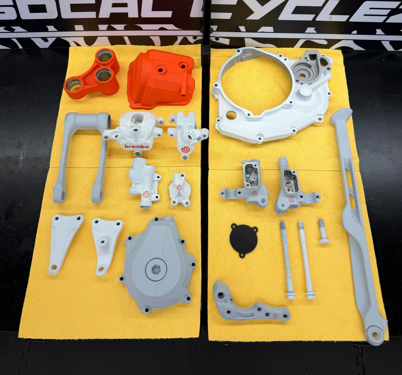 Freshly coated motorcycle parts laid out after coating